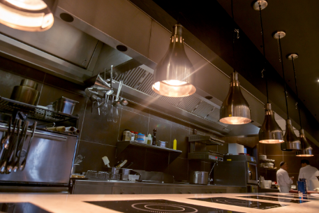 Heat lamps hanging over a clean kitchen line